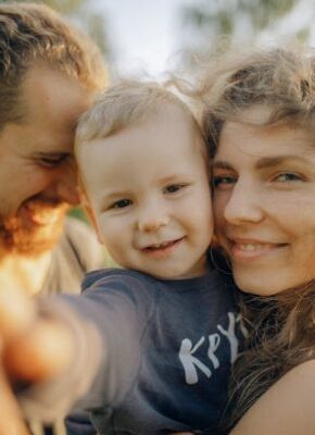 Close-up of a happy family with a smiling child enjoying outdoor time together.